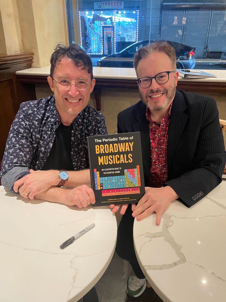 Authors Andrew Gerle and Joseph Zellnik holding up a copy of their book, THE PERIODIC TABLE OF BROADWAY MUSICALS
