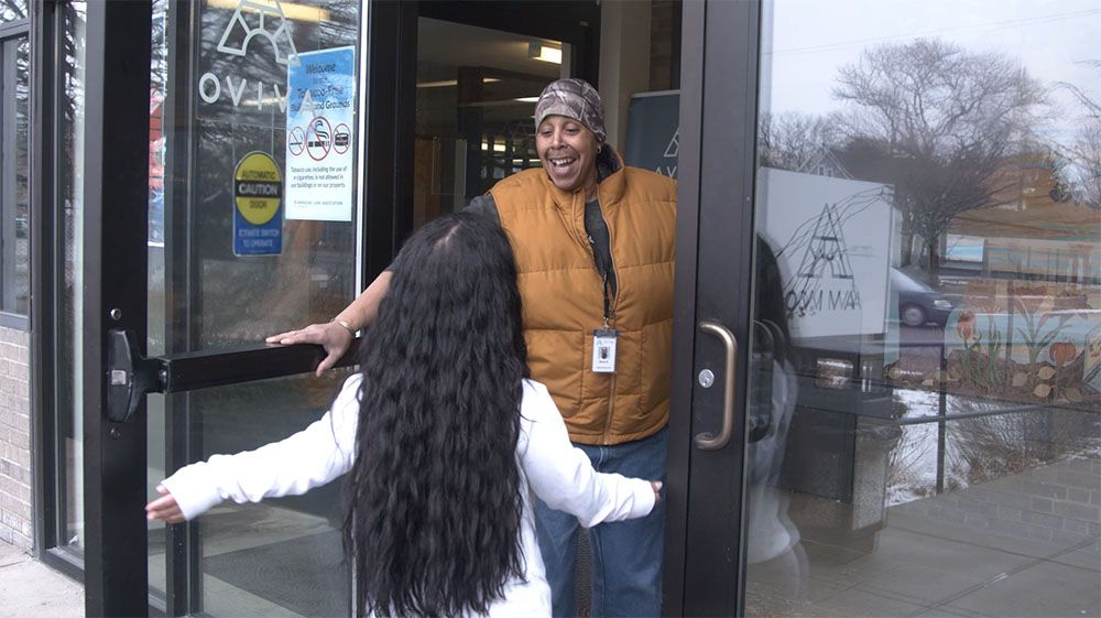 Image of an Avivo staff person opening the door for an Avivo program participant.