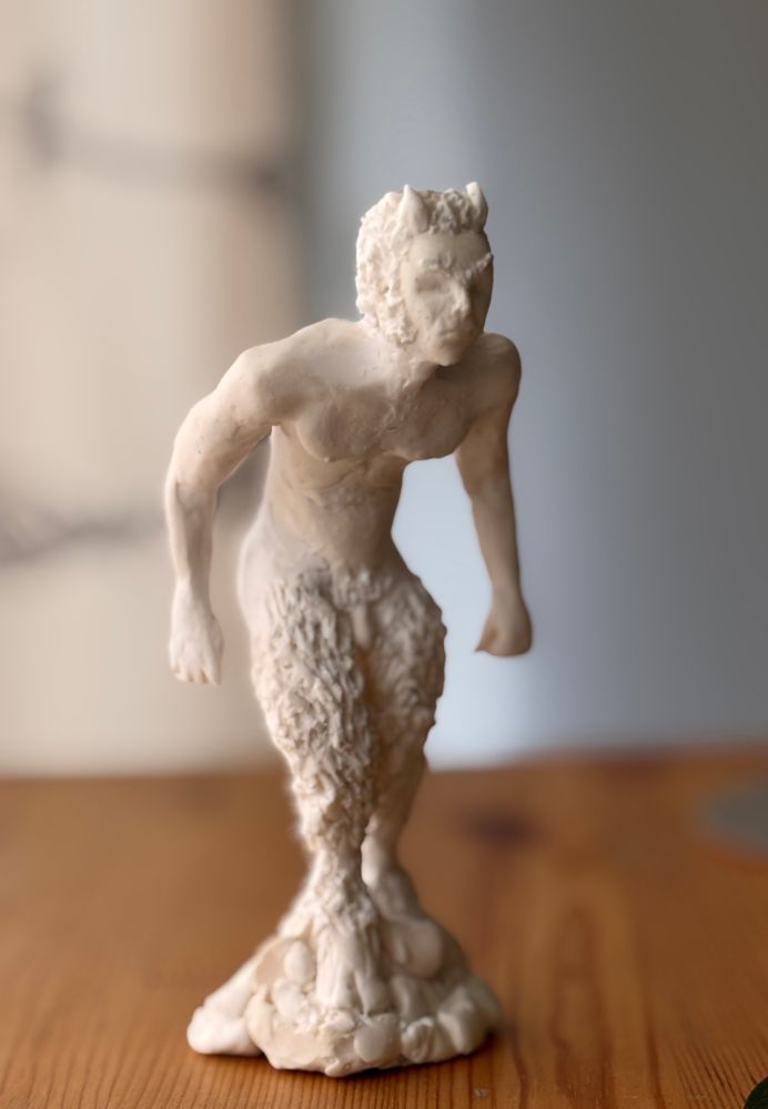 Sculpture of a hairy-legged, hooved, hunched satyr or faun, with thick sideburns and small horns