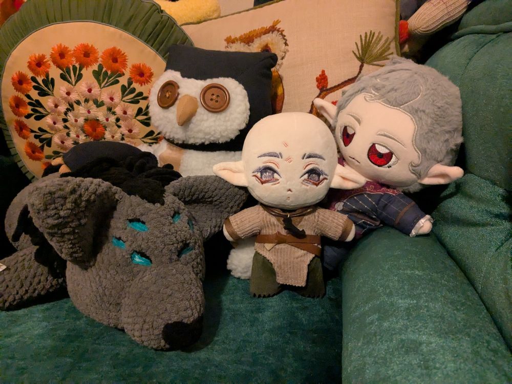 four stuffed plushies: Solas and his Dread Wolf form from Dragon Age, and Astarion and the owl bear plushie from Baldur's Gate 3