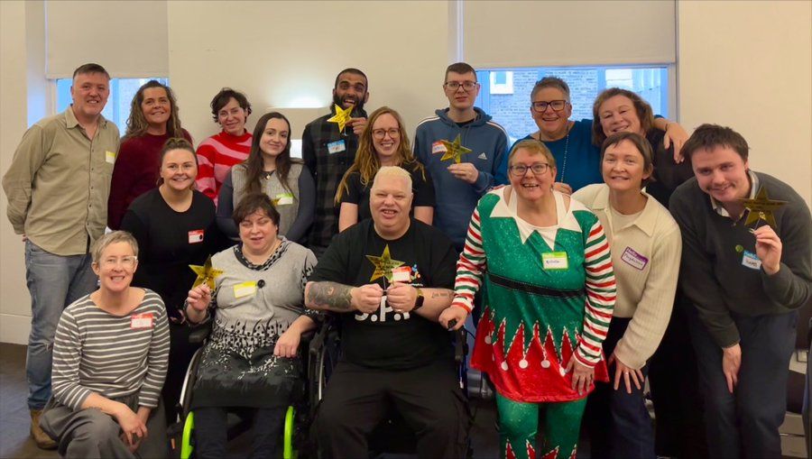 A group of 16 of us. A festive elf in the front row. A group of disabled and non disabled researchers posing after a day of hard work!