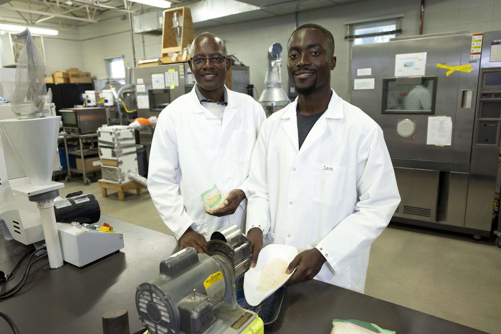 Griffiths Atungulu and Samuel Oloani, both wearing lab coats, pose for a photo in a lab environment.