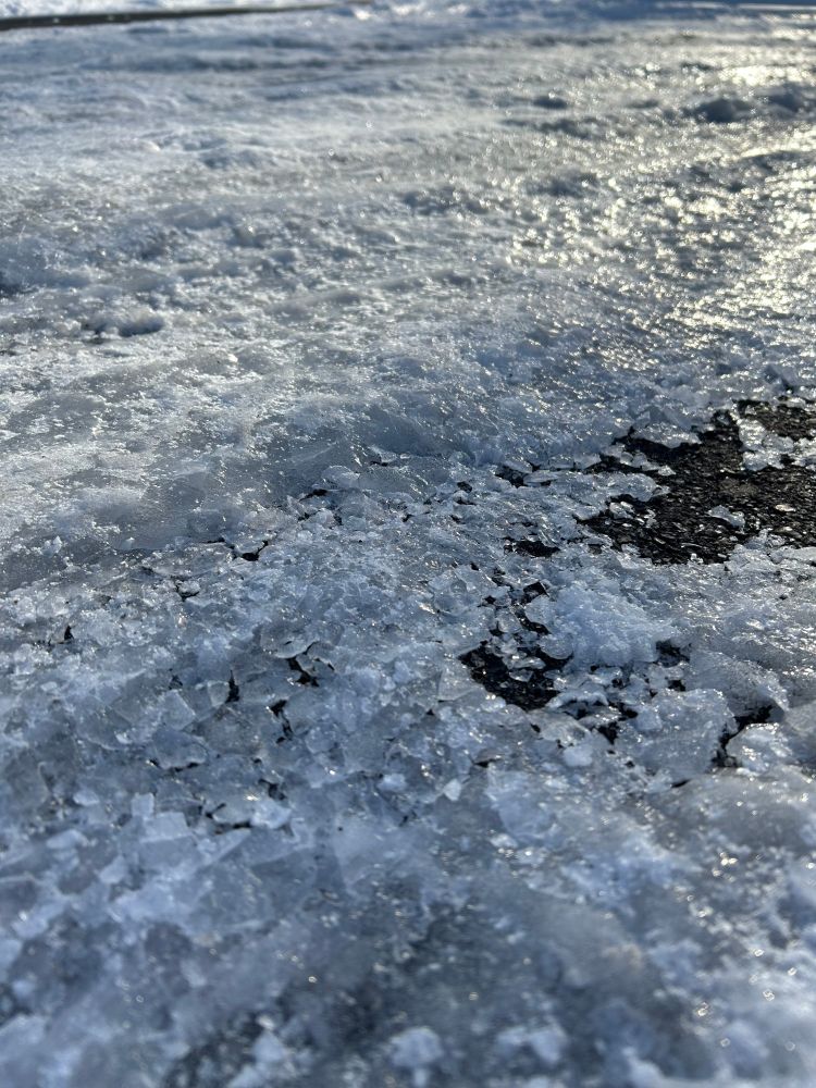 Close up photo of snow and ice on an asphalt road