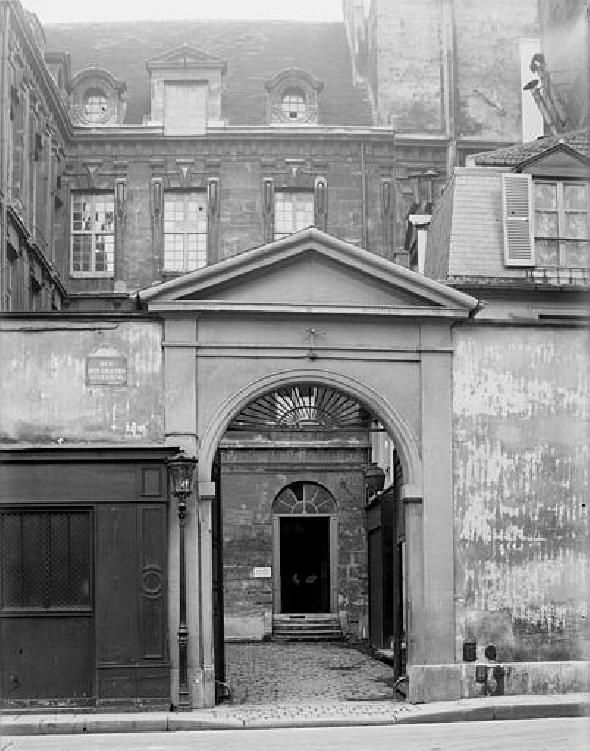 Una fotografía en blanco y negro muestra el portal de la dirección que aparece en el tuit.
Un arco de estilo neoclásico da entrada a un patio descubierto que da acceso al edificio.