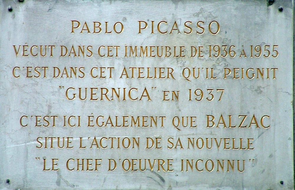La imagen muestra una placa con el siguiente texto en francés:
Pablo Picasso vivió en este inmueble de 1936 a 1955. Fue en este estudio donde pintó "Guernica" en 1937.
Es aquí también donde Balzac sitúa la acción de su novela "La obra maestra desconocida".