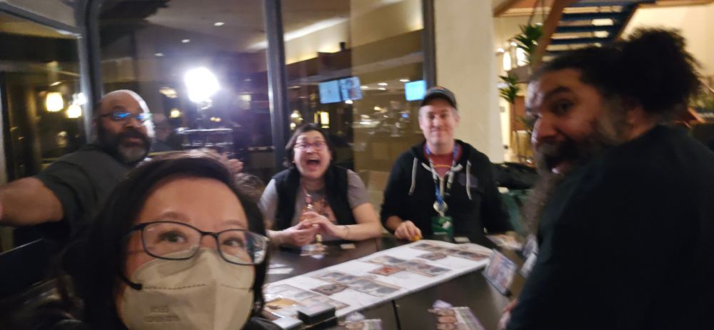 Selfie by Panda of her, Ashwin, Jess, David, and Joe playing a board game in the hotel lobby.