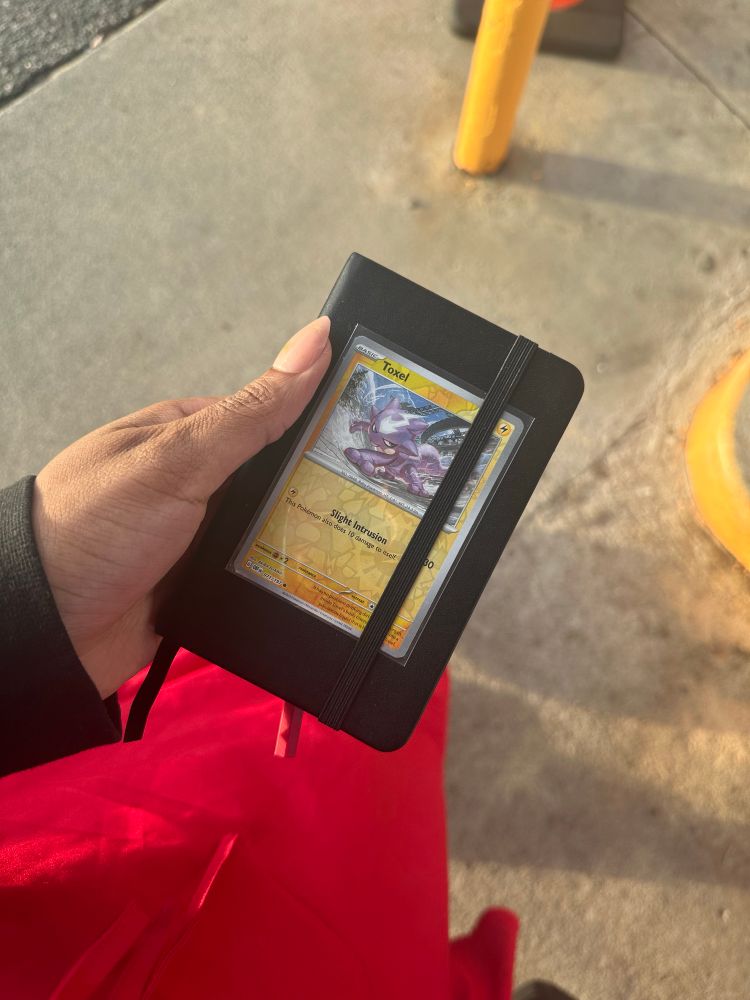 A decorated sketchbook with a Pokemon card 