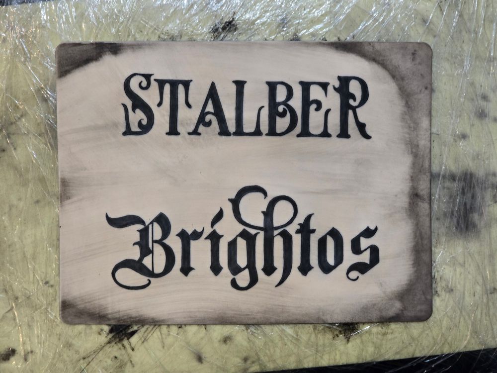 Practice tattoos of old Gothic-style fonts on fake skin.