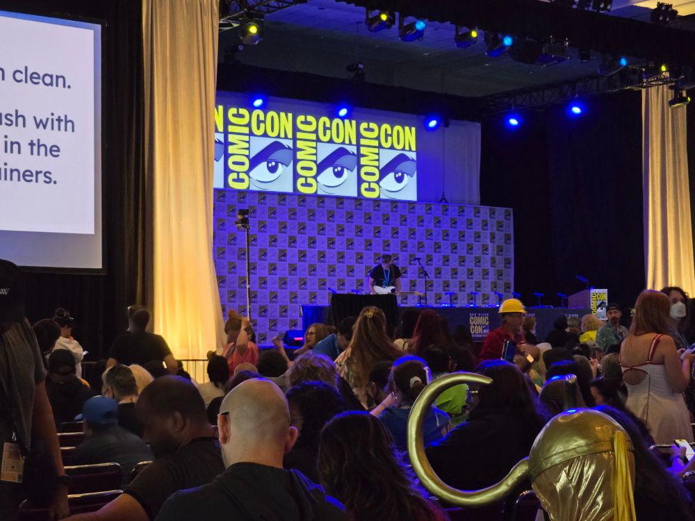 Man with electric guitar setting up on stage of Ballroom 20 for the IWTW panel