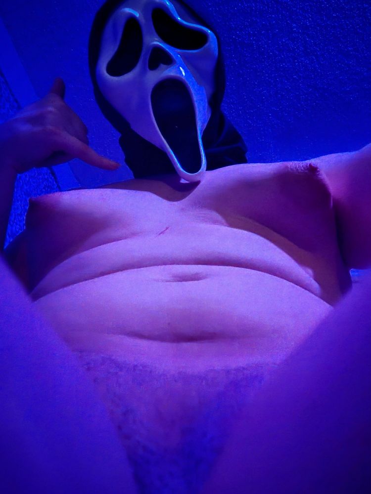 B wearing only a ghost face mask while she straddles the camera with her thighs making a call me sign with her hand.

skyhub
