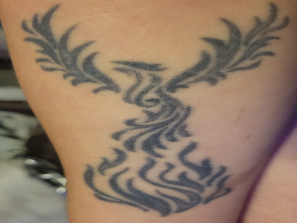 a tattoo of a Phoenix coming out of flames with wings outstretched in black ink