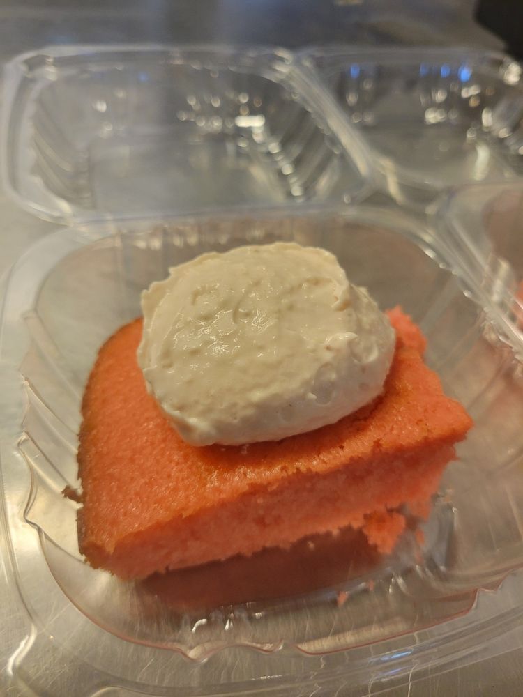 strawberry cake with cream cheese frosting in a clear box