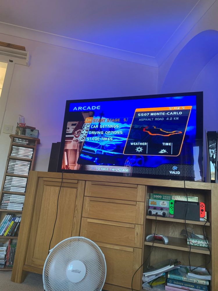 Picture of a television stand and a TV playing V-Rally 2