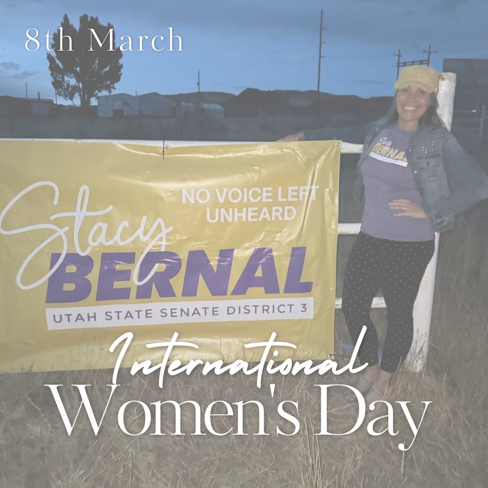 Woman standing by a campaign banner that reads: Stacy Bernal, Utah Senate District 3. No Voice Left Unheard. 