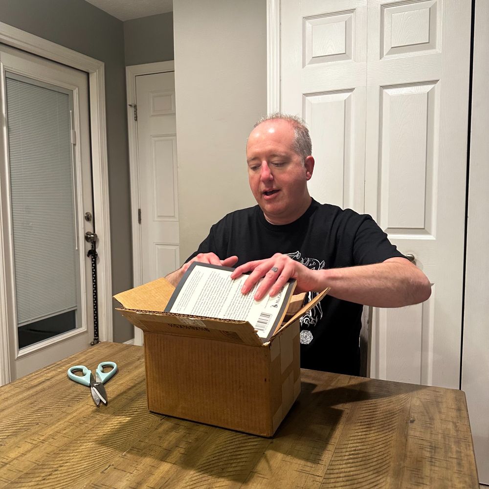 Adam Watson unboxing his book "Tabletop Role-Playing Games in the Classroom."