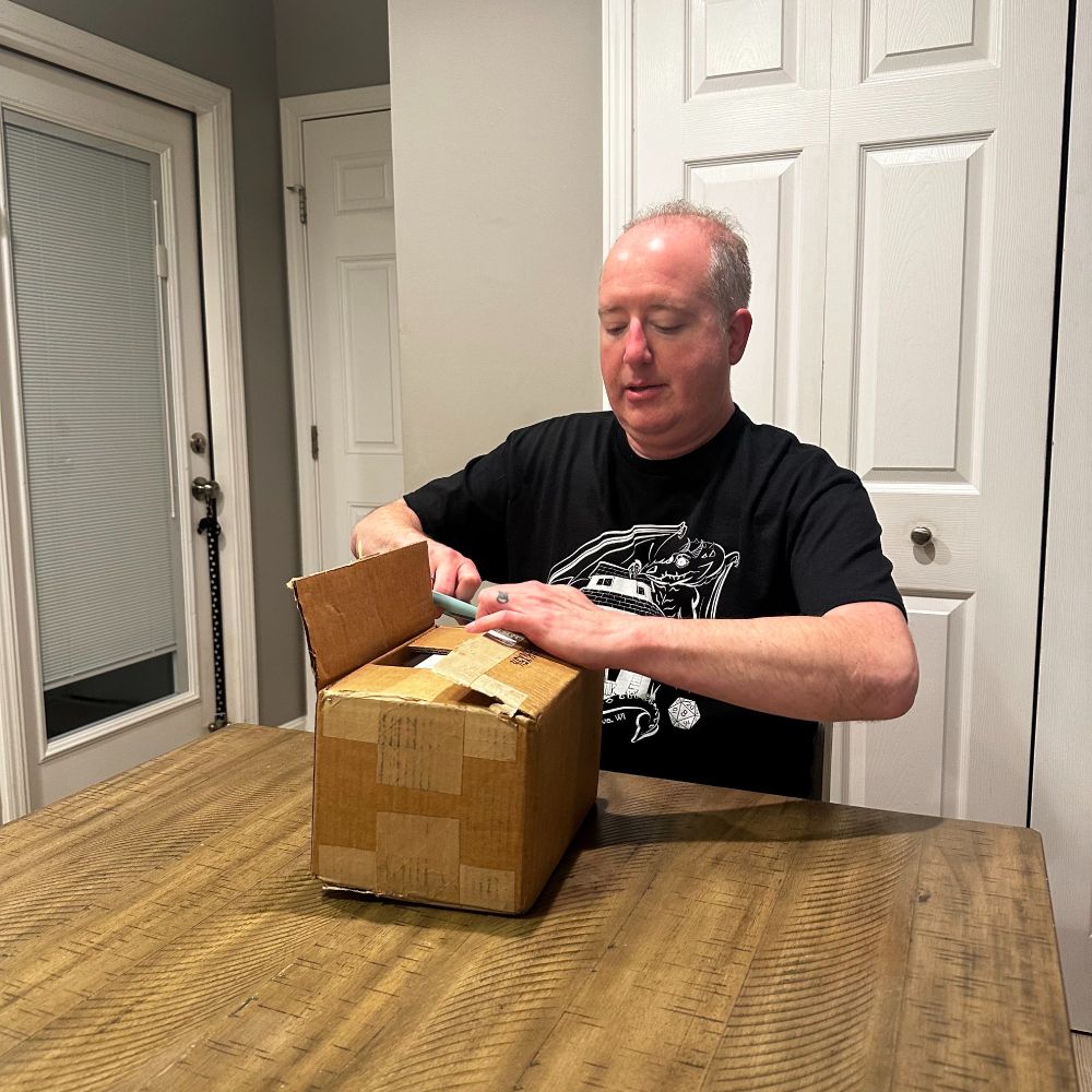 Adam Watson unboxing his book "Tabletop Role-Playing Games in the Classroom."