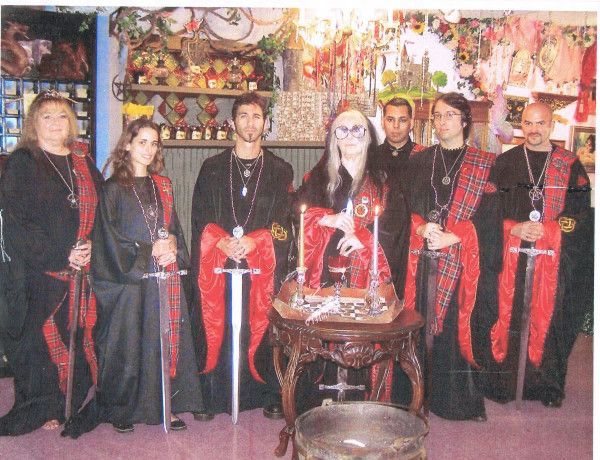 7 Witches in Black and Red Robes before an altar, all holding Excalibur Swords. Front Center, Sully Erna, Laurie Cabot & Christopher Penczak