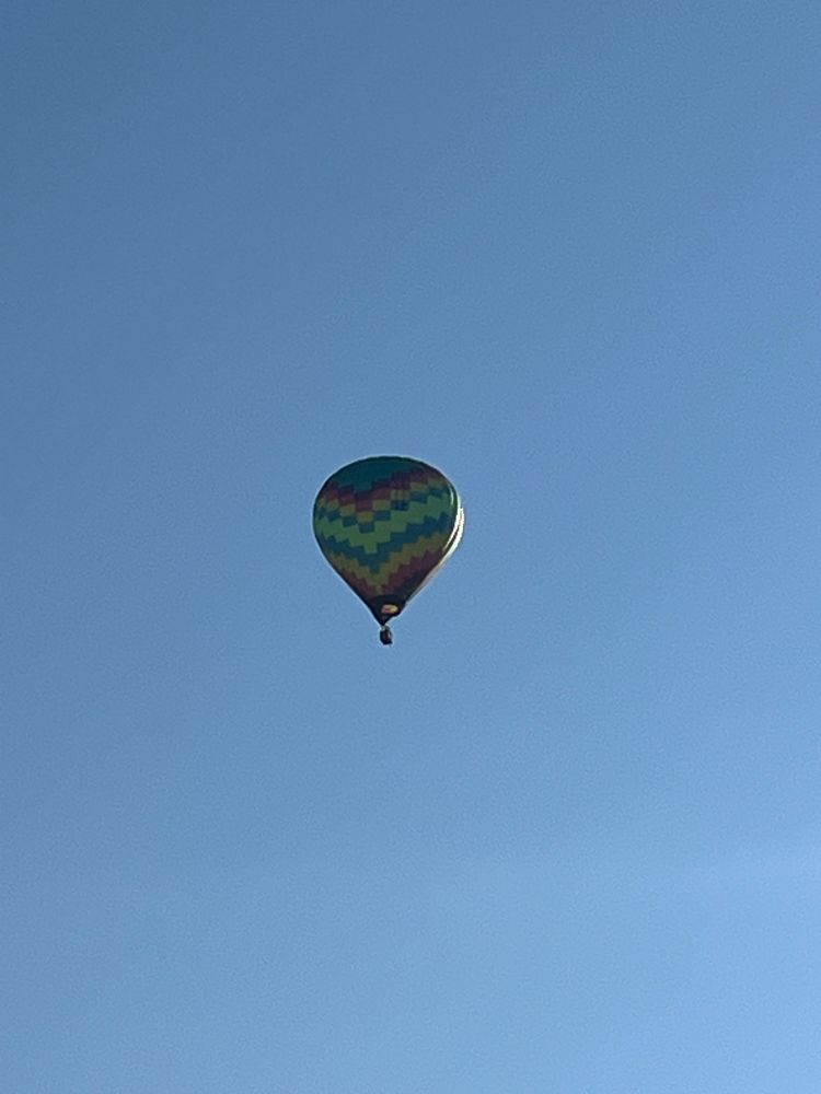 A hot air balloon with pixelated rainbow pattern 