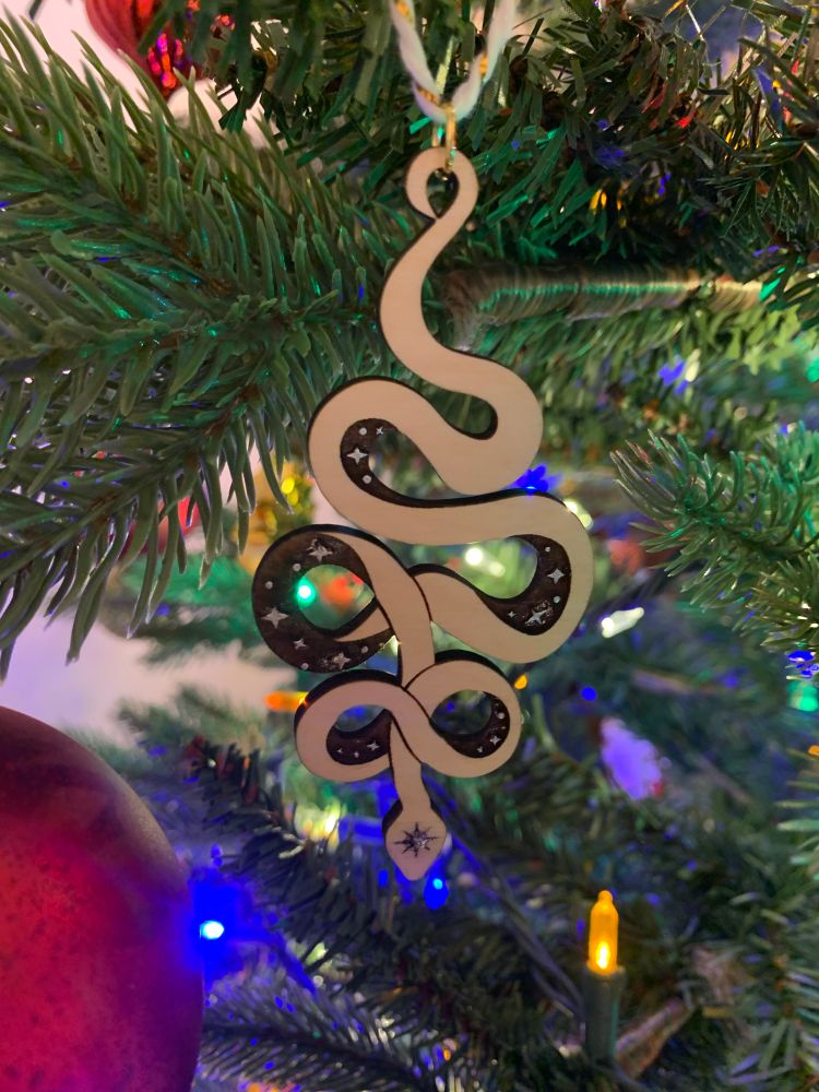 Starmaker serpent ornament hanging on a Christmas tree