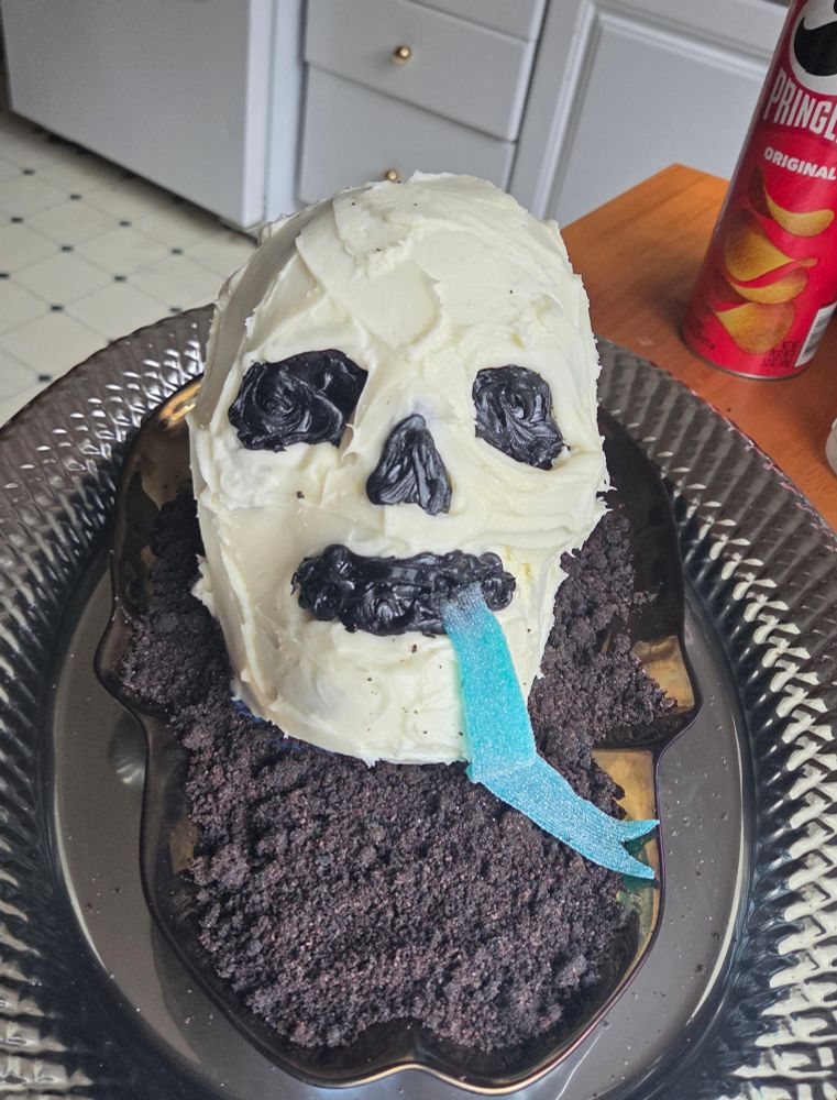 Skull cake frosted on a platter with a blue candy tongue