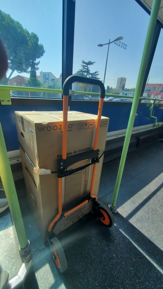 Boxed air conditioner on a hand truck on a bus
