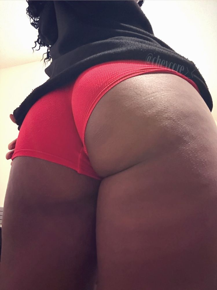 A photo of chev showing off their booty and thighs. They are wearing red boxers with a black hoodie. 