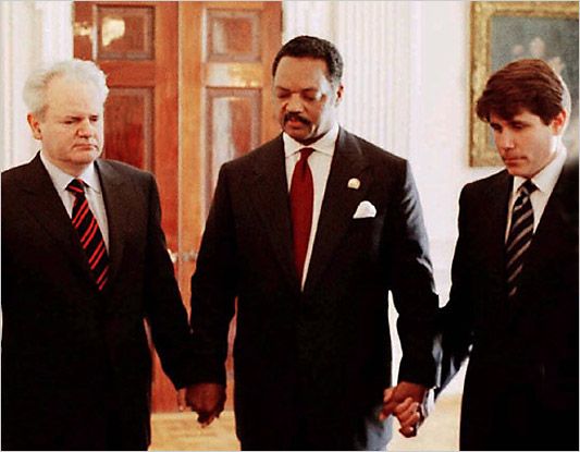 Rod Blagojevich, Rev. Jesse Jackson, and war criminal Slobodan Milošević hold hands in prayer 