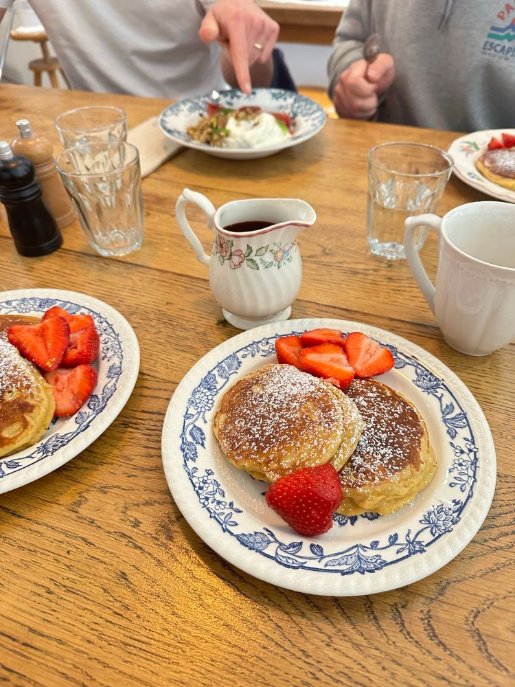 Une assiette de pancakes saupoudrés de sucre glace avec des fraises