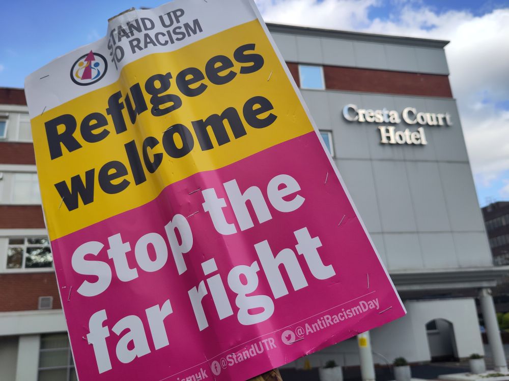 An anti-racist placard reads "Stand Up To Racism, Refugees welcome, stop the far right" in front of the Cresta Court hotel, Altrincham
