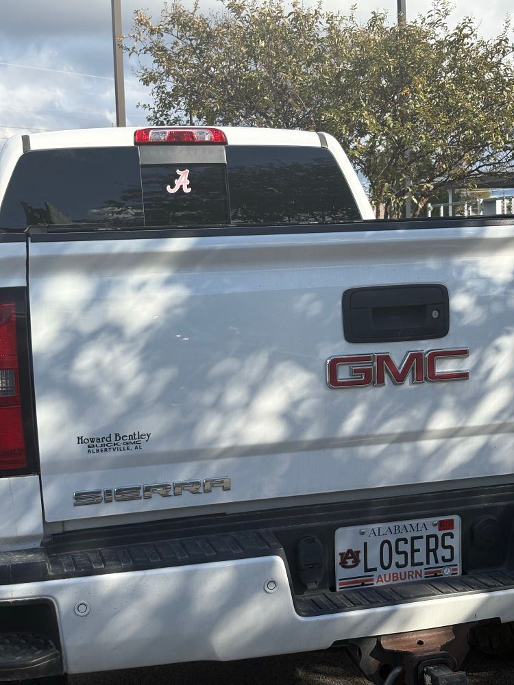 A pickup truck with an Auburn University state of Alabama issued license plate with the message LOSERS with an Alabama window sticker 