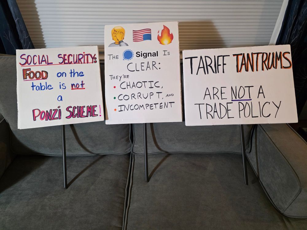 Three protest signs that read 