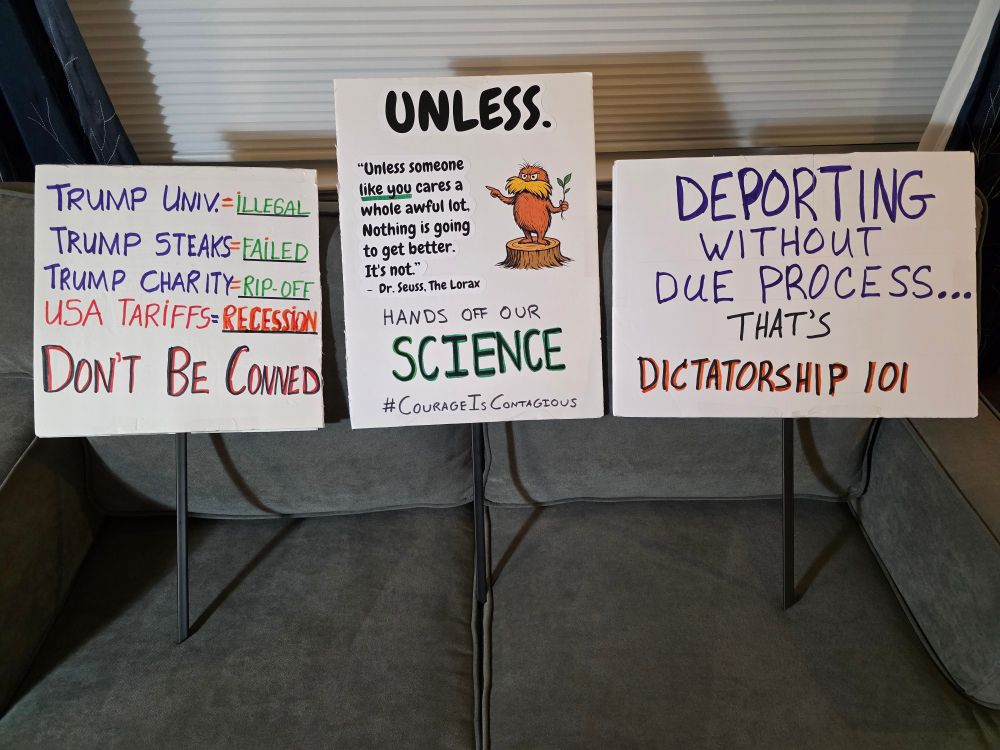 Three protest signs that read 