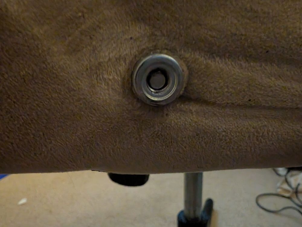 the armrest/backrest connection point with a sheered off screw end, lodged deep within.