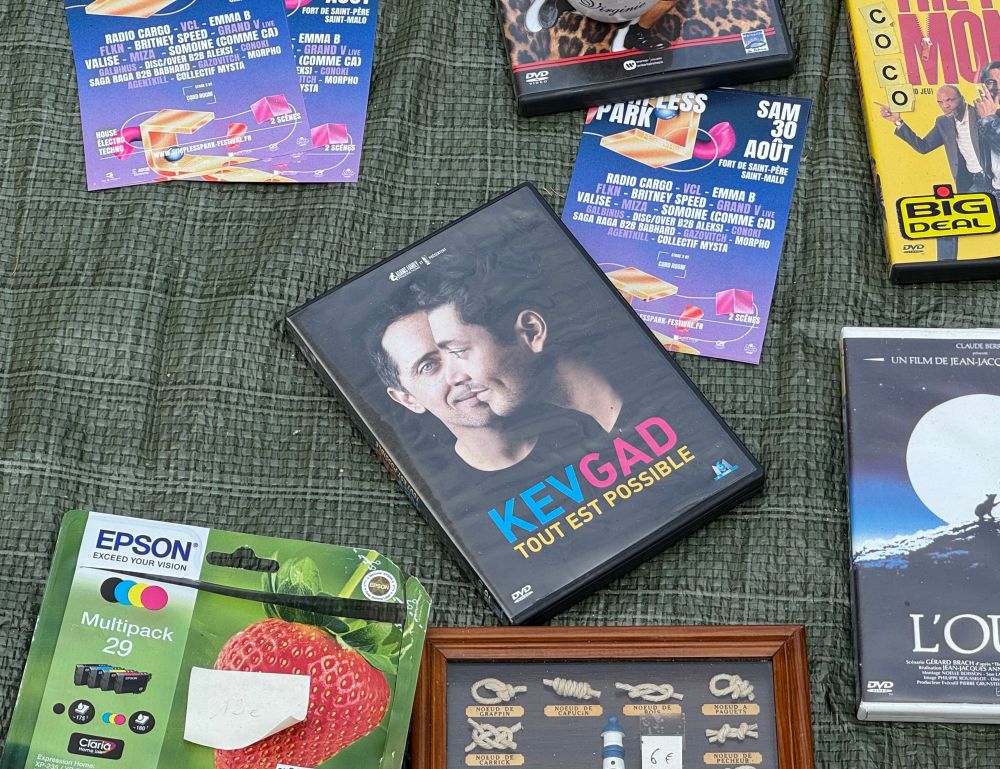 Au milieu de plusieurs objets, un DVD du spectacle de Gad Elmaleh et Kev Adams "Tout est possible"