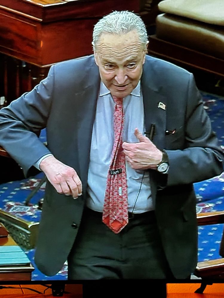 chuck schumer on the senate floor with his tie flipped backwards