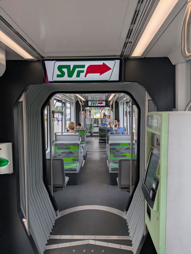 Stylized logo mounted in a team car so that it is pointing right when the exit is to the left