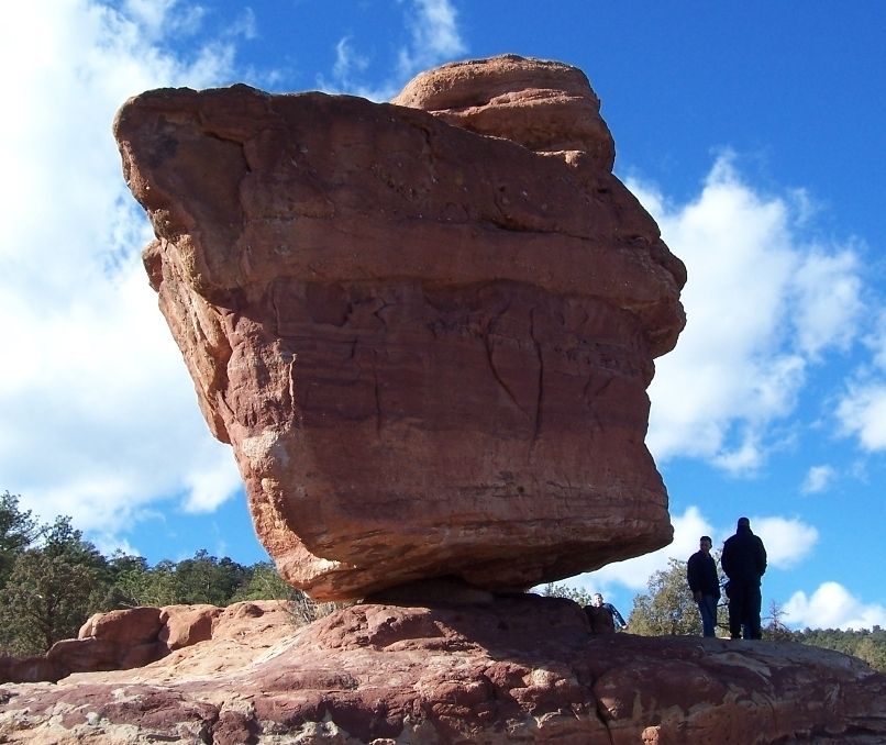 Boulder with 2 people looking tiny next to it