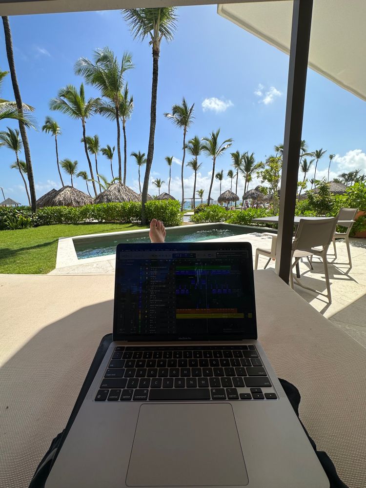 Lounging in a cabana by the pool while I produce music on my laptop