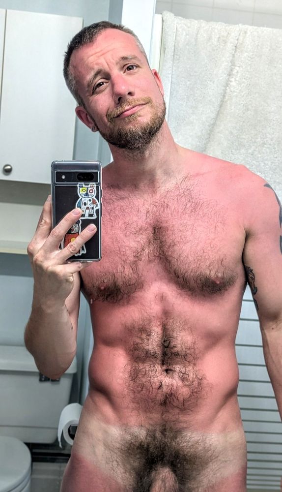 Bathroom mirror selfie, very evident tan line skin red (from the sun) showing bush and shaft while flexing abs. 