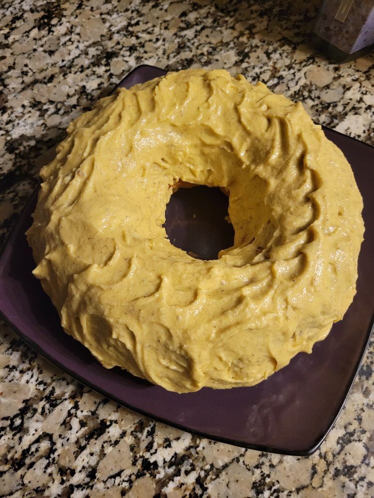 Yellow/Lemon brown butter frosted bundt cake on a purple plate 