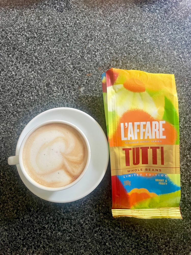 Mushroom cloud latte in a white coffee cup made from Tutti beans on a black granite bench