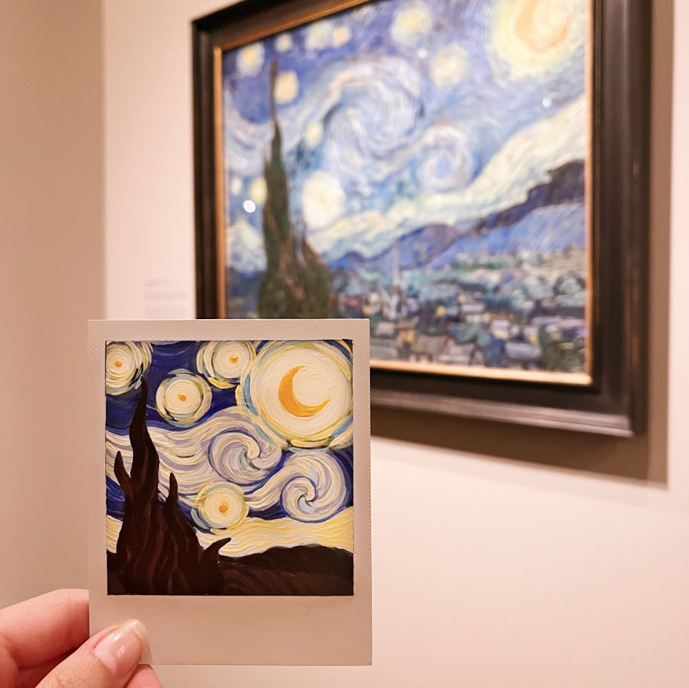 a tiny painting of starry night in front of the real starry night painting