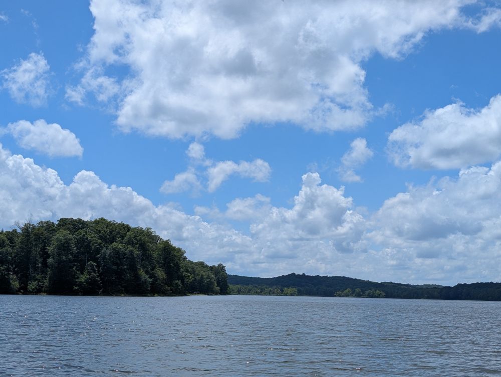 un lago y el cielo azul y nublado. 