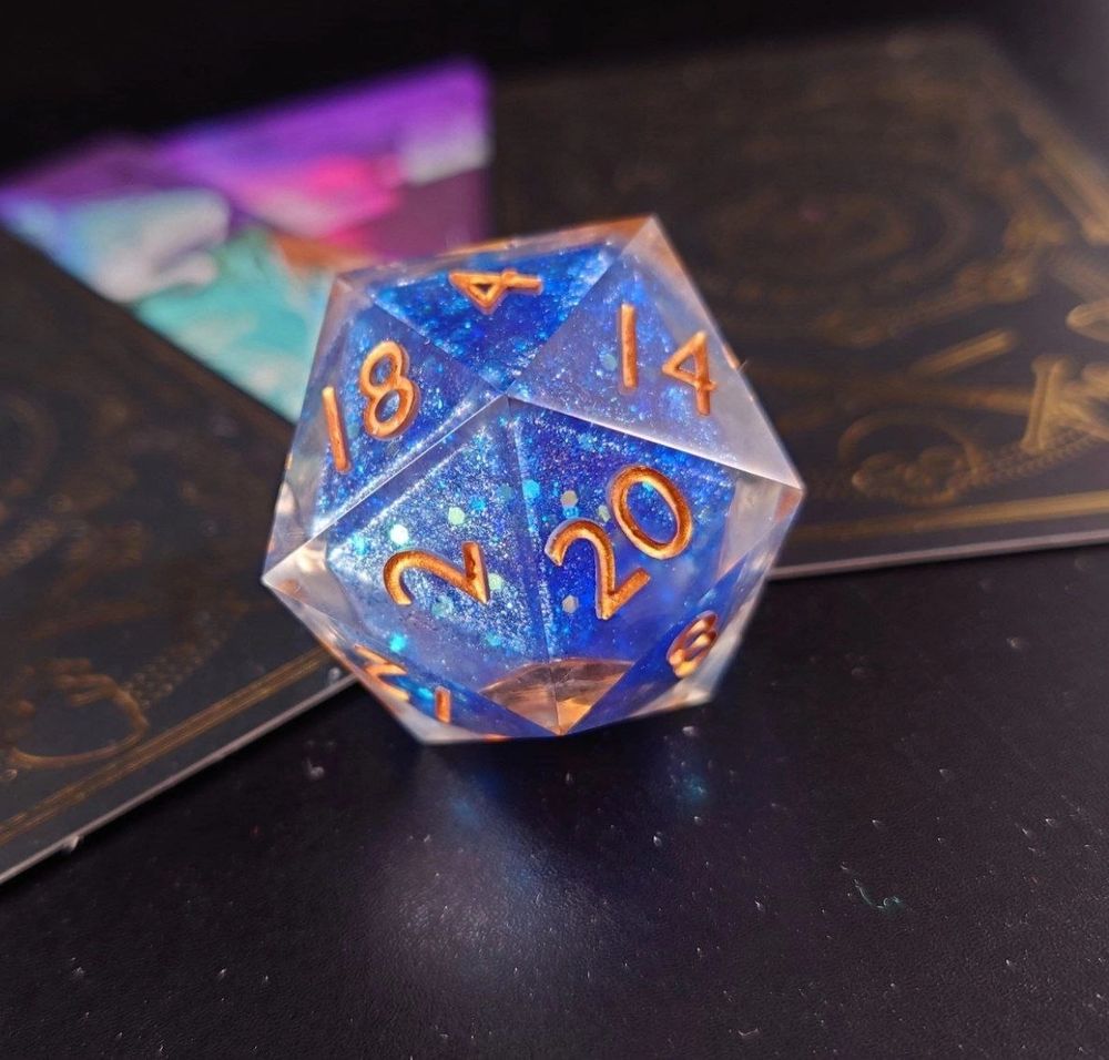 a blue d20 with a liquid core and golden numbers