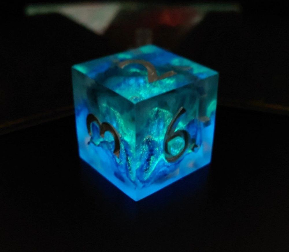 a luminescent six-sided die with a foggy mountain inside