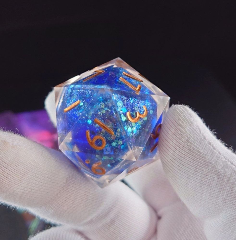 a blue d20 with a liquid core and golden numbers