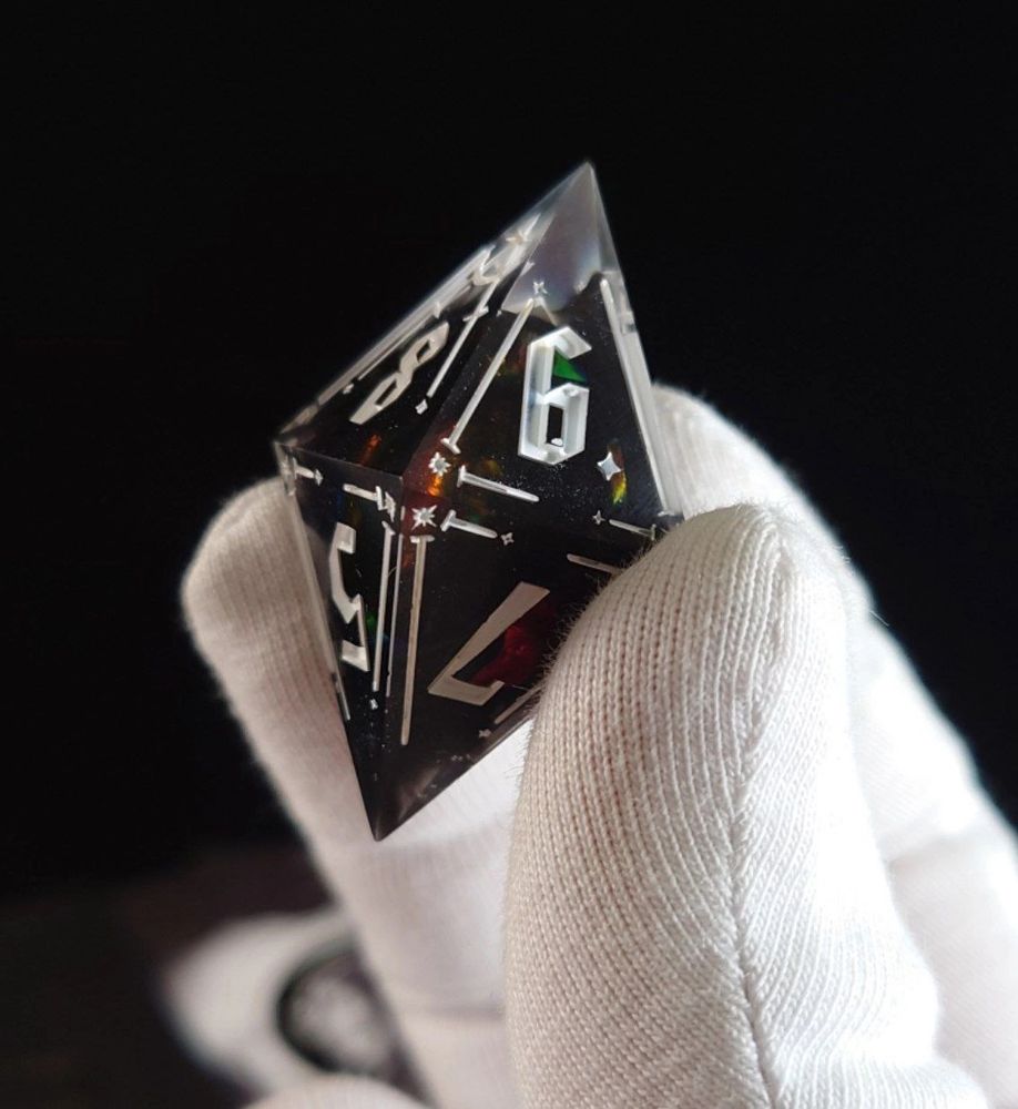 a black eight-sided die with white numbers and stars
