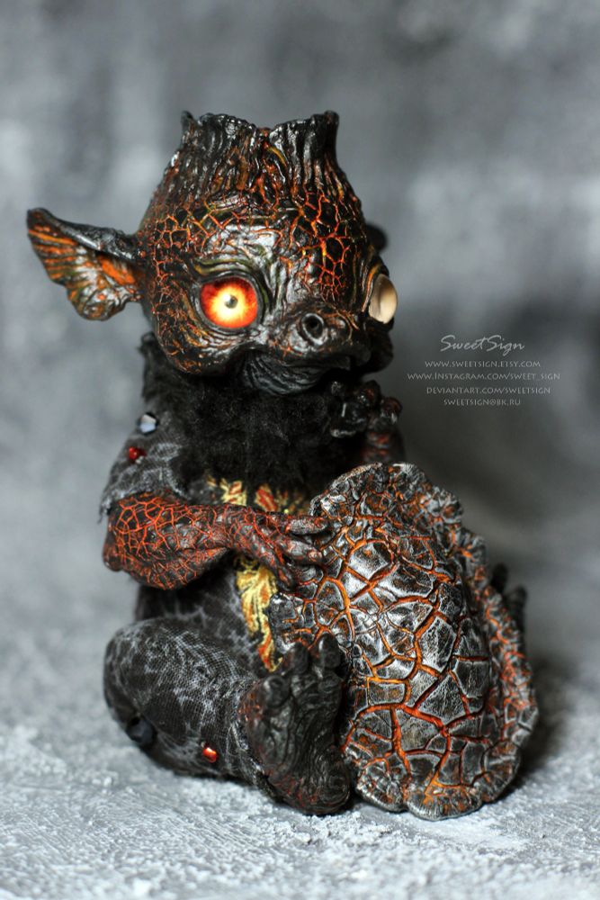 Kappa Volcano, original fantasy art doll.

It is a creature living in a volcano’s funnel. Kappas of the kind must keep their emotions in check or they become dangerous for themselves. On the one hand, they can literally burst out of boiling anger or keen excitement, which together with the creature’s death provokes the effusion of lava. That is why kappas of the kind avoid of knowing news or discussing with others their likes or dislikes. On the other hand, they should not stay calm and still for long: if their inner fire fades away they become sleepy and if the lava in their headbowls turns to a piece of obsidian, they sink into a deep sleep forever looking just like stone statues. It is almost impossible to meet a human in such a place as a volcano funnel, so kappas of the kind don’t take humans for enemies. However if a kappa is young, it feels so surprised that it usually finishes terribly for both the kappa and the human traveller, that is why you’d better not attract its attention if your way led you yet to a funnel settled by kappas.