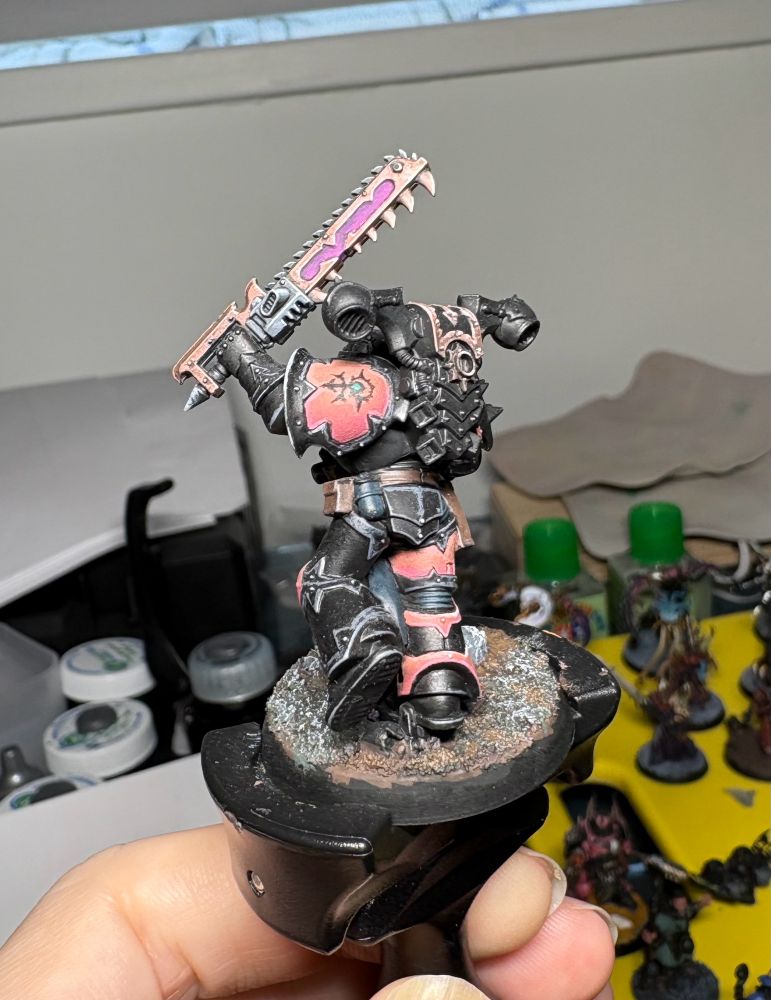 Chaos space marine painted black and pink, rear view.