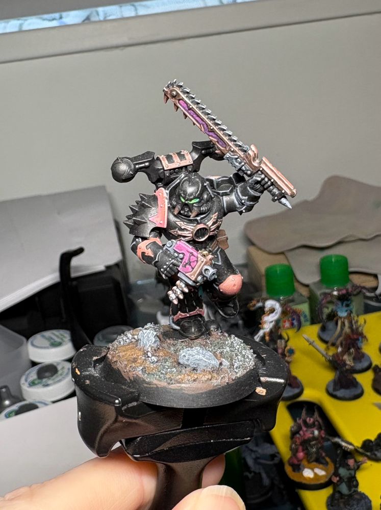 Chaos space marine painted black and pink, front view.
